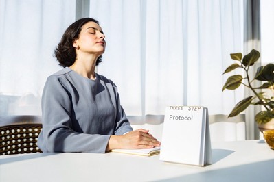 Professional pausing with eyes closed before a video meeting