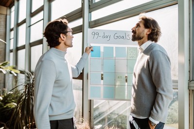 Leader and coach reviewing a 90-day goals board