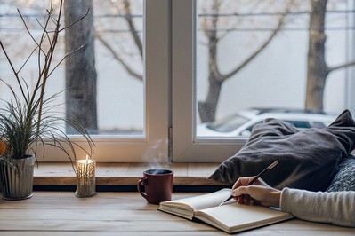 Person journaling beside a window on a late-November evening