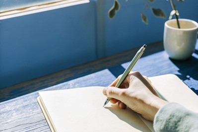 hand writing three past wins in a notebook