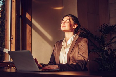 professional pausing at laptop to breathe