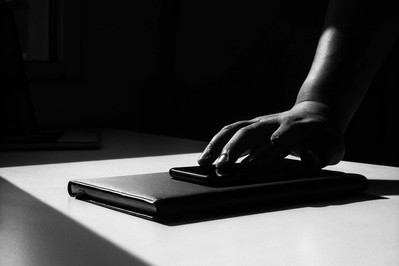 person putting phone face down next to notebook