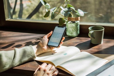 person setting phone face-down beside a paper notebook
