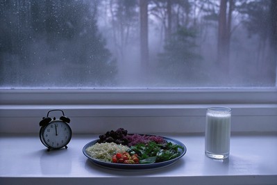 Šareni tanjur s raznim biljkama i čašom kefira uz sat