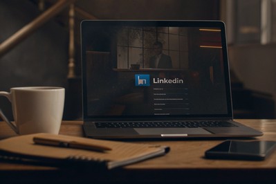 radni stol s kavom i otvorenim LinkedIn profilom