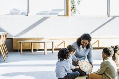 Teacher guiding a diverse classroom check-in with an emotion wheel