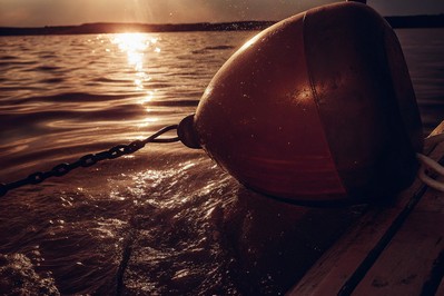 anchored buoy at sunrise in choppy water