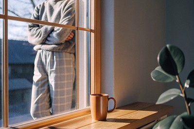 person standing tall by a morning window