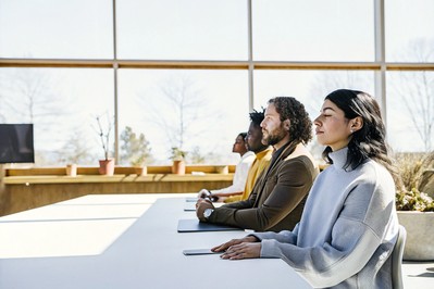 Colleagues pausing for a brief mindful breath before a meeting