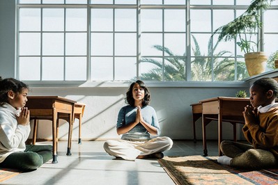 Teacher modeling a slow breath while students mirror