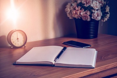 timer, notebook, and phone facedown on a quiet desk