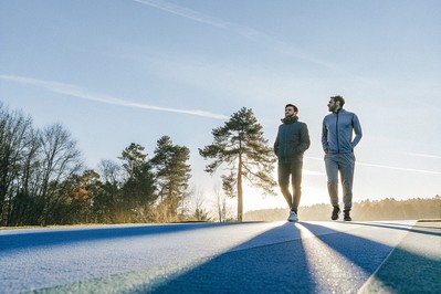 Executive and athlete walking in a quiet forest at sunrise