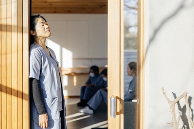 Clinician pausing for a single mindful breath at a doorway