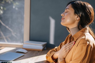 Professional doing a brief breathing practice at a desk